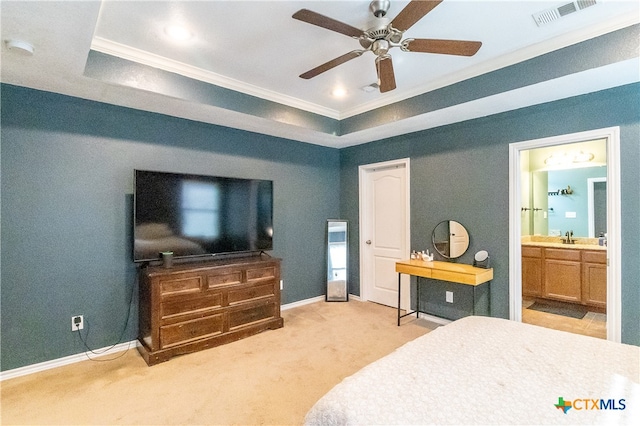 carpeted bedroom with ensuite bathroom, sink, crown molding, ceiling fan, and a tray ceiling