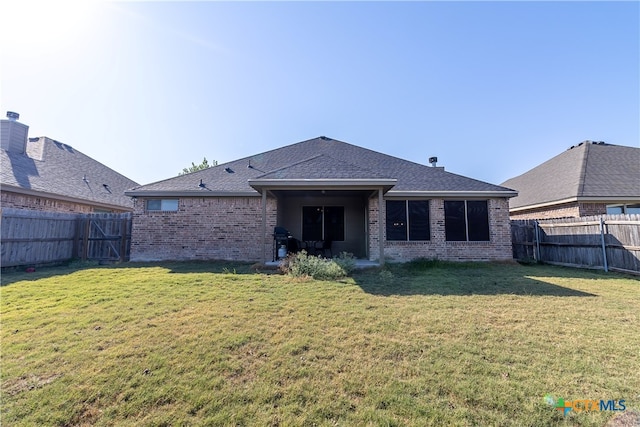 back of house featuring a lawn