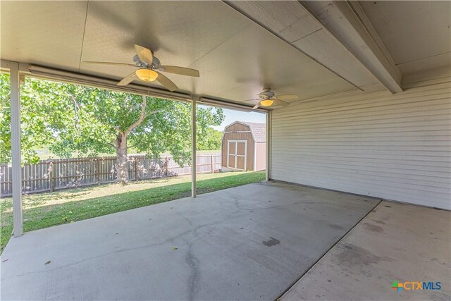 view of patio / terrace with an outdoor structure, a ceiling fan, a shed, and a fenced backyard