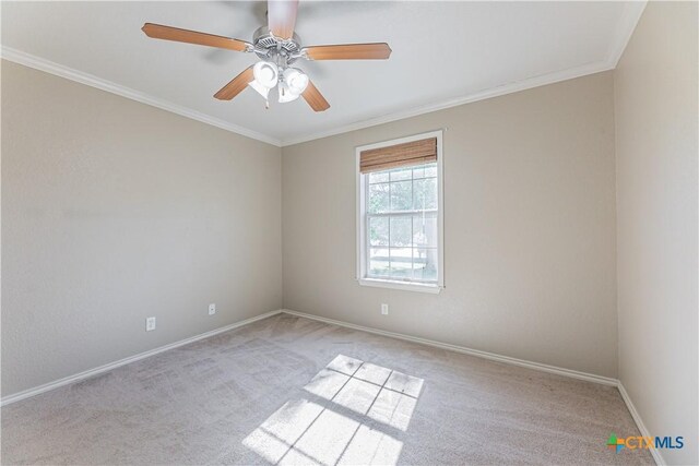 carpeted spare room with a ceiling fan, baseboards, and ornamental molding