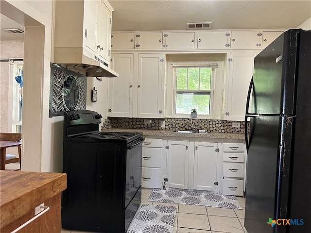 kitchen featuring white cabinets, black appliances, a textured ceiling, light tile patterned flooring, and backsplash