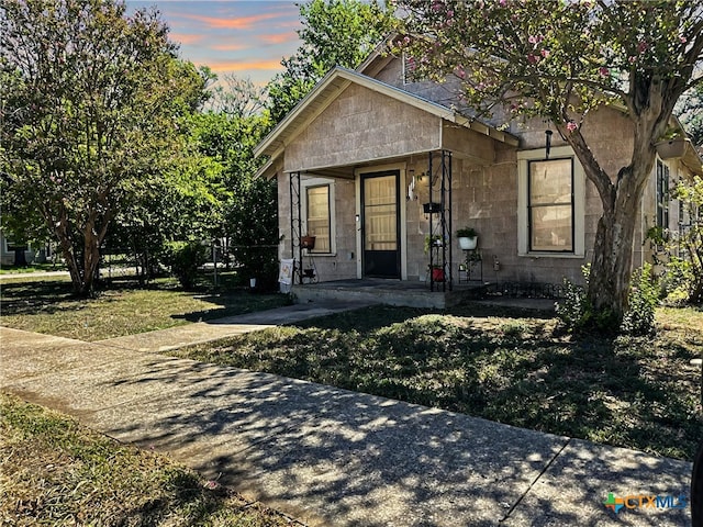 view of front of house with a porch and a yard