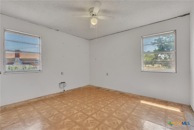 empty room featuring a textured ceiling and ceiling fan