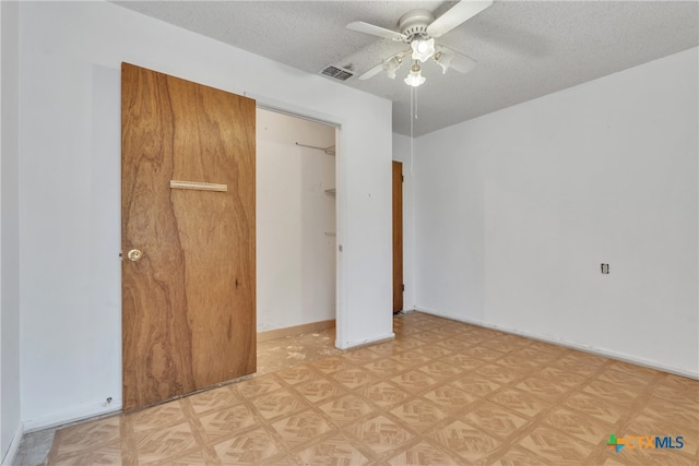 unfurnished bedroom with ceiling fan, a textured ceiling, and a closet