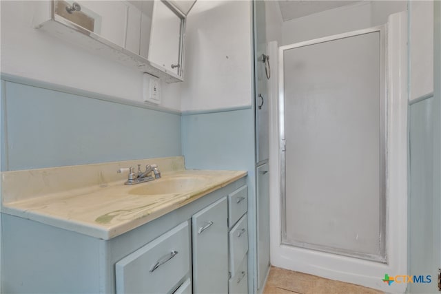 bathroom featuring walk in shower, tile patterned flooring, and vanity