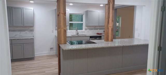 kitchen featuring light wood-type flooring, black electric stovetop, tasteful backsplash, and gray cabinetry