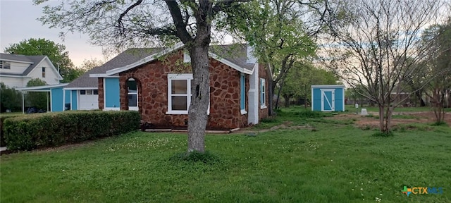 property exterior at dusk featuring a storage unit and a lawn