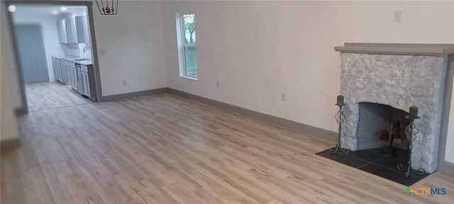 unfurnished living room featuring sink and light wood-type flooring