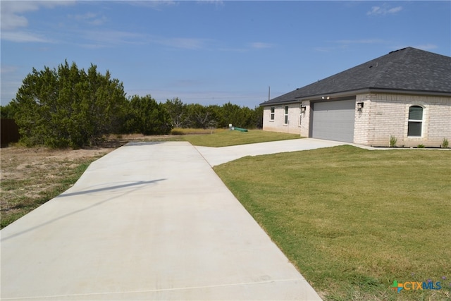 view of side of property featuring a garage and a lawn