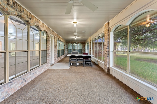 unfurnished sunroom with ceiling fan