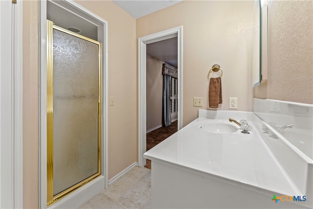 bathroom featuring tile patterned flooring, vanity, and a shower with door