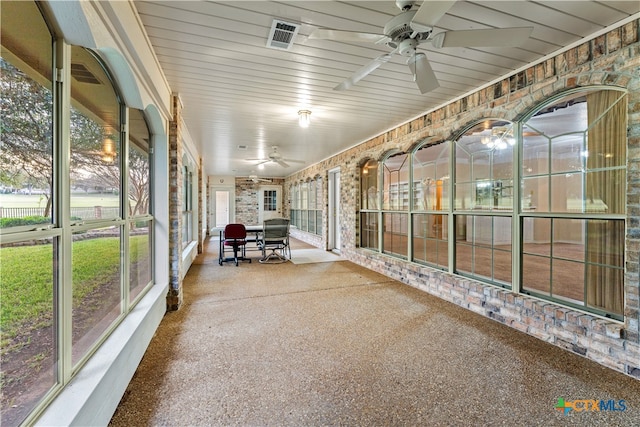 unfurnished sunroom featuring ceiling fan and wood ceiling