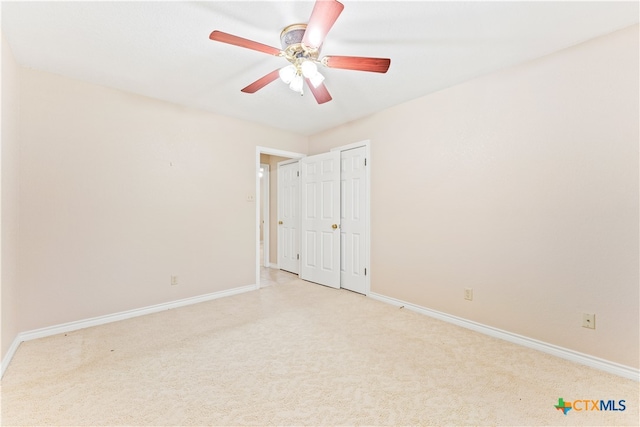 unfurnished bedroom with ceiling fan and light colored carpet