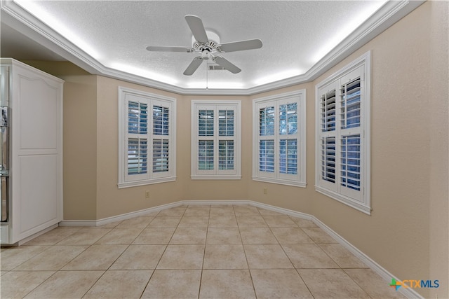 empty room featuring light tile patterned floors, a textured ceiling, ceiling fan, and crown molding