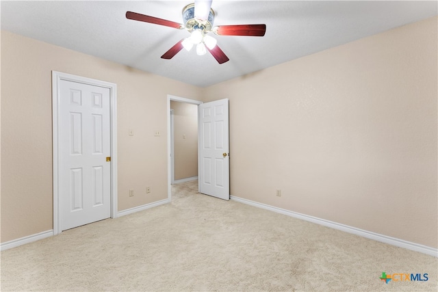 unfurnished bedroom featuring light carpet and ceiling fan