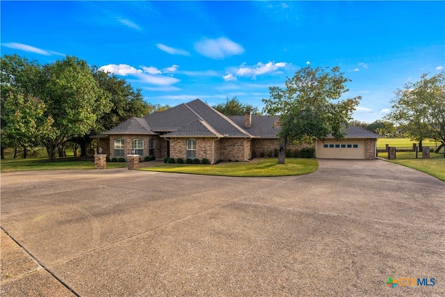 ranch-style house featuring a garage and a front yard