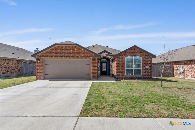 ranch-style home featuring a front yard, brick siding, fence, and an attached garage