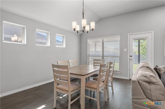 dining space featuring dark wood-style flooring, a wealth of natural light, an inviting chandelier, and lofted ceiling