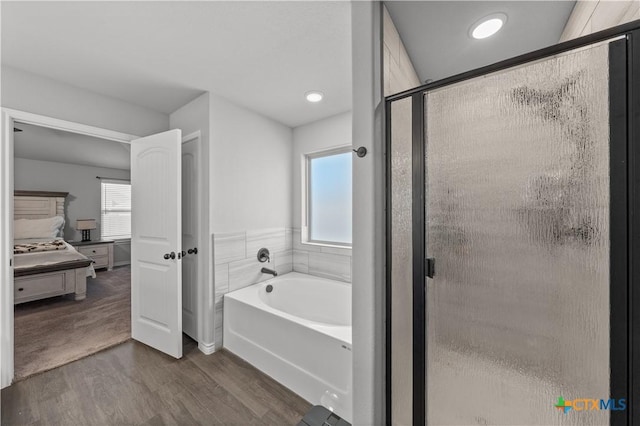 full bathroom featuring a bath, a stall shower, ensuite bath, and wood finished floors