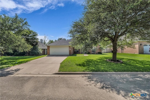 5708 High Meadow Dr, Temple, TX 76502 - view of property hidden behind natural elements with driveway, a front lawn, an attached garage, and brick siding
