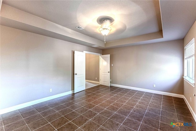 243 Arendes Dr, New Braunfels, TX 78132 - spare room with ceiling fan, dark tile patterned floors, baseboards, and a raised ceiling
