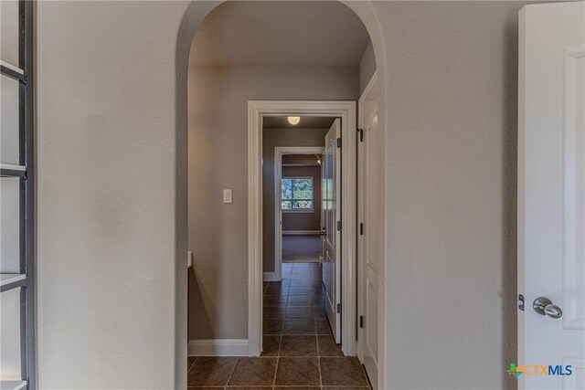 hallway with dark tile patterned flooring