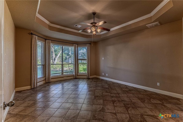 unfurnished room with ceiling fan, a raised ceiling, and ornamental molding