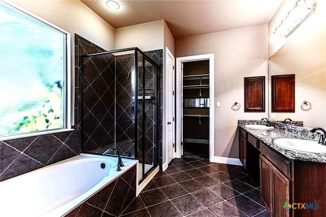 243 Arendes Dr, New Braunfels, TX 78132 - full bathroom featuring a shower stall, double vanity, a bath, tile patterned flooring, and baseboards