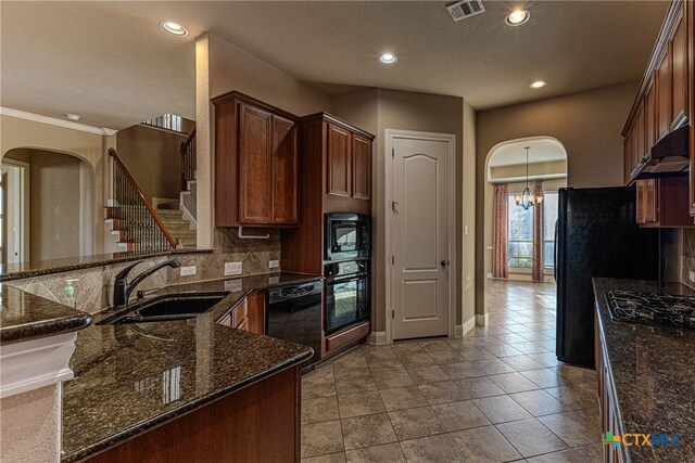 kitchen with dark stone counters, decorative backsplash, sink, and black appliances