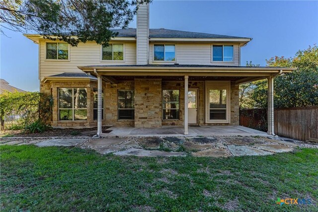 rear view of house with a lawn and a patio area