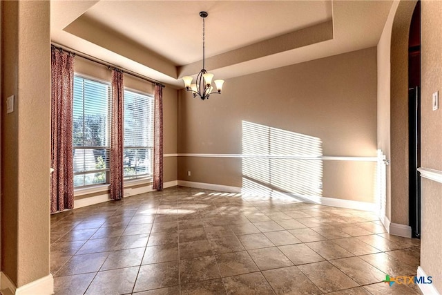 243 Arendes Dr, New Braunfels, TX 78132 - tiled empty room featuring a chandelier, a raised ceiling, arched walkways, baseboards, and a textured wall