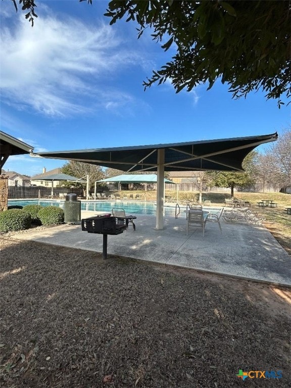view of community featuring a swimming pool and fence
