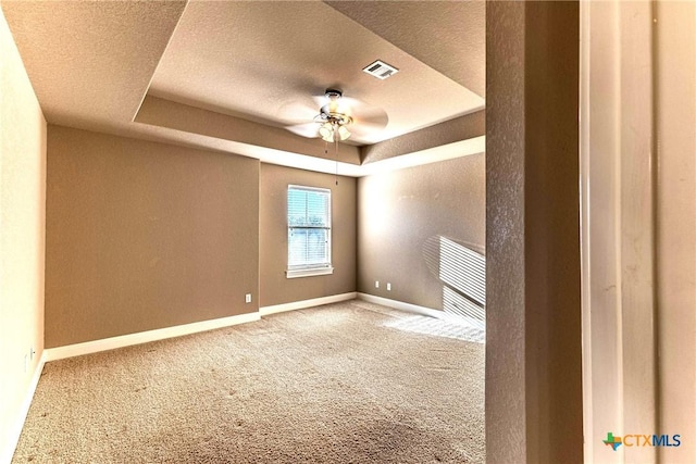 243 Arendes Dr, New Braunfels, TX 78132 - empty room featuring carpet floors, a raised ceiling, a textured ceiling, baseboards, and a ceiling fan