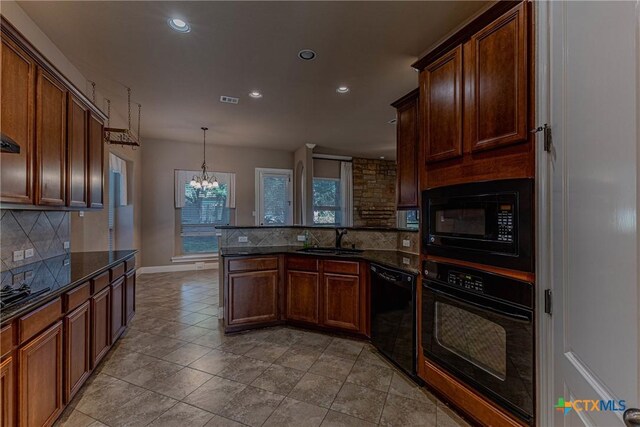 kitchen featuring sink, a notable chandelier, dark stone counters, pendant lighting, and black appliances