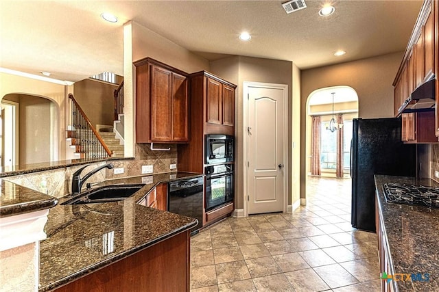 243 Arendes Dr, New Braunfels, TX 78132 - kitchen featuring a sink, black appliances, decorative backsplash, arched walkways, and a peninsula