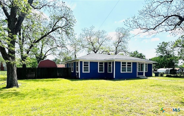 view of home's exterior with fence and a yard