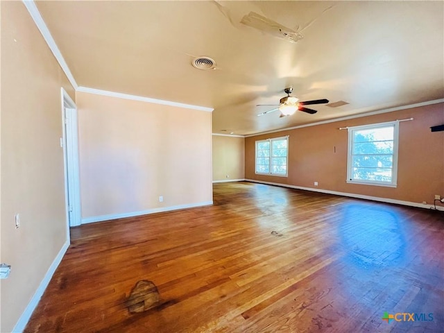 empty room with hardwood / wood-style floors, visible vents, crown molding, baseboards, and ceiling fan