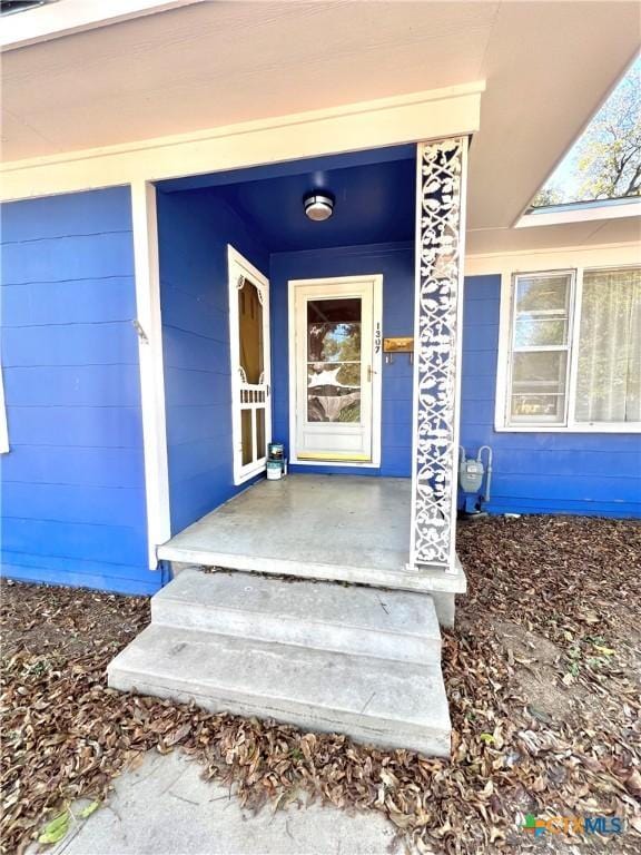 view of exterior entry with covered porch