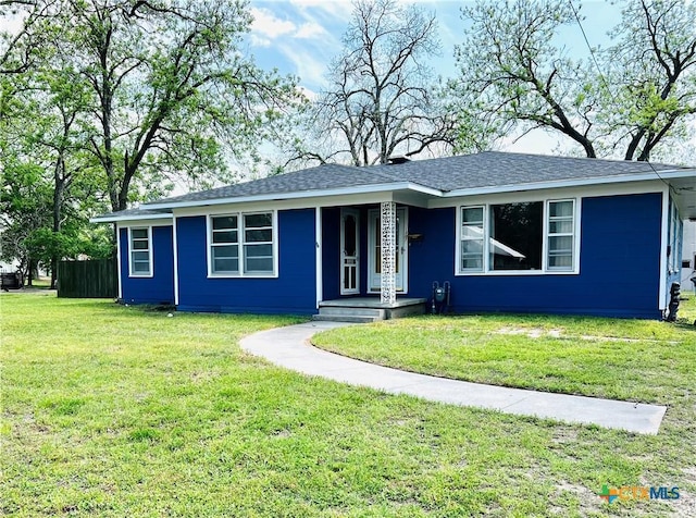 ranch-style home featuring roof with shingles and a front yard