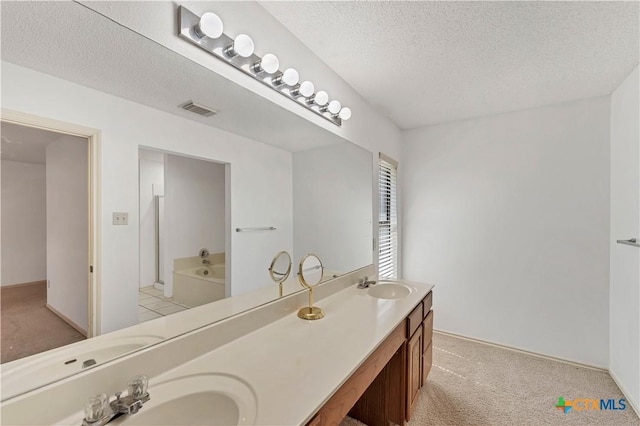 full bathroom featuring visible vents, a textured ceiling, and a sink