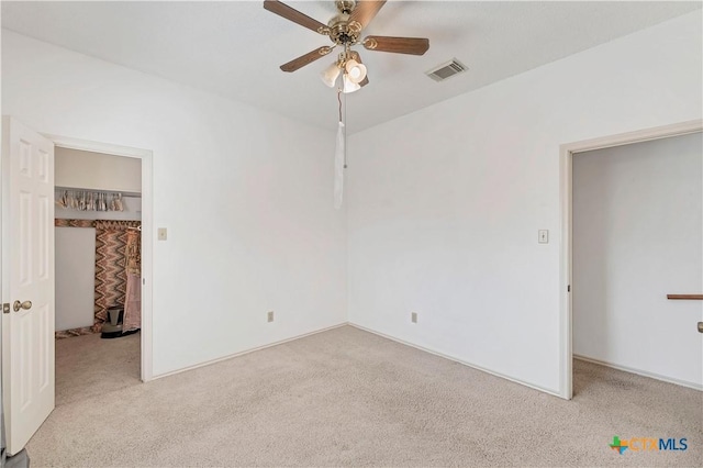 unfurnished bedroom featuring visible vents, carpet floors, a closet, and a spacious closet