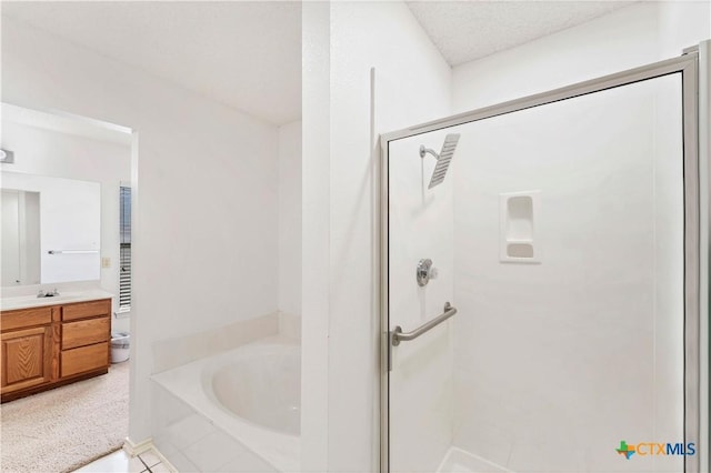 full bathroom with a garden tub, a stall shower, vanity, and a textured ceiling