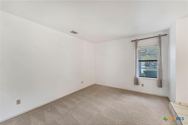 empty room with visible vents and light carpet