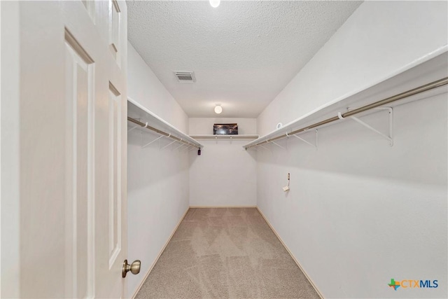 spacious closet featuring visible vents and light colored carpet