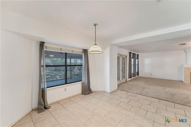 empty room featuring light tile patterned floors, french doors, light carpet, and baseboards