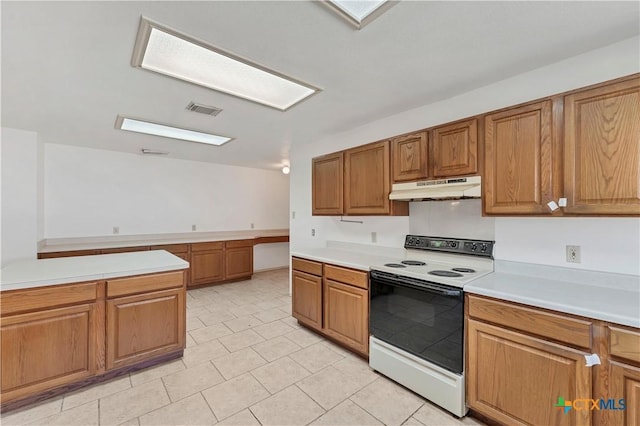 kitchen with visible vents, under cabinet range hood, light countertops, brown cabinets, and white range with electric stovetop