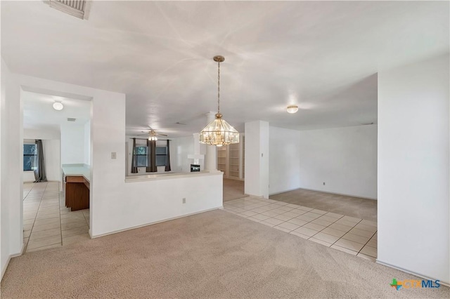 interior space featuring tile patterned floors, visible vents, carpet floors, and an inviting chandelier