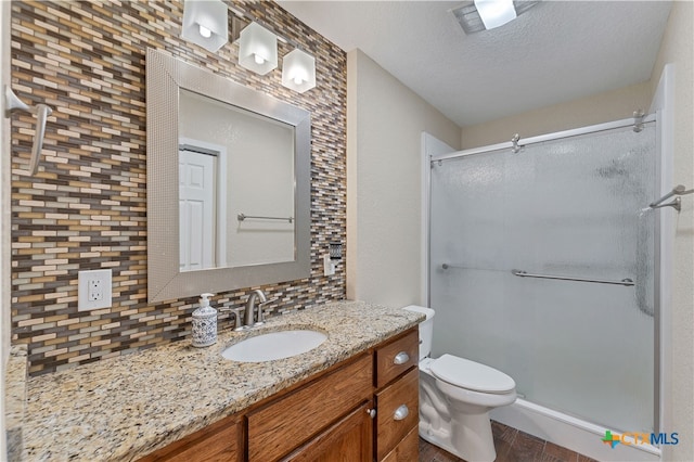 bathroom with tasteful backsplash, walk in shower, vanity, hardwood / wood-style flooring, and toilet