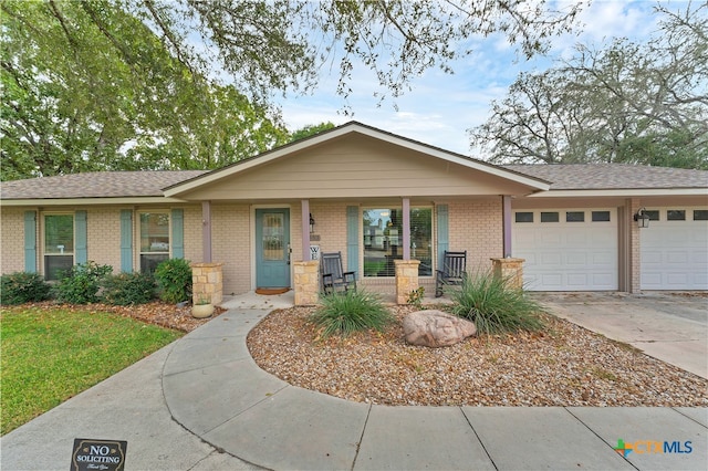 ranch-style home with a garage and covered porch