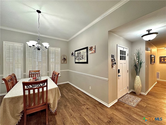 dining space featuring a chandelier, wood-type flooring, and ornamental molding